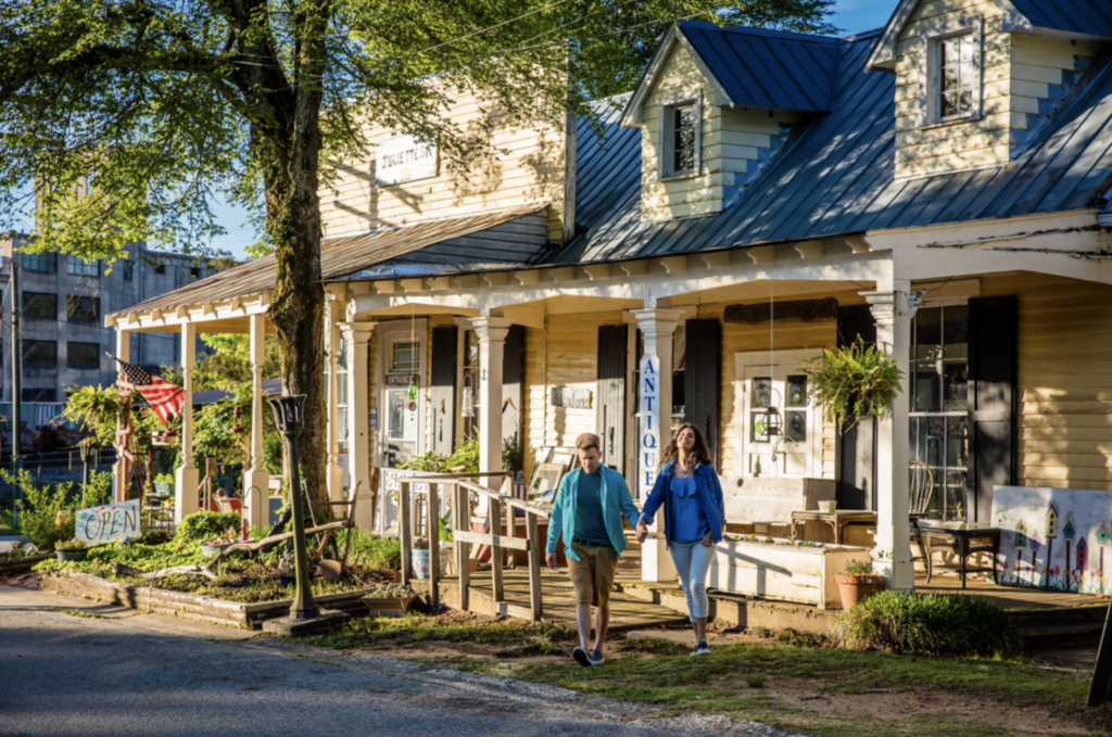 a row of historic homes now hosting shops site along a road with people walking by